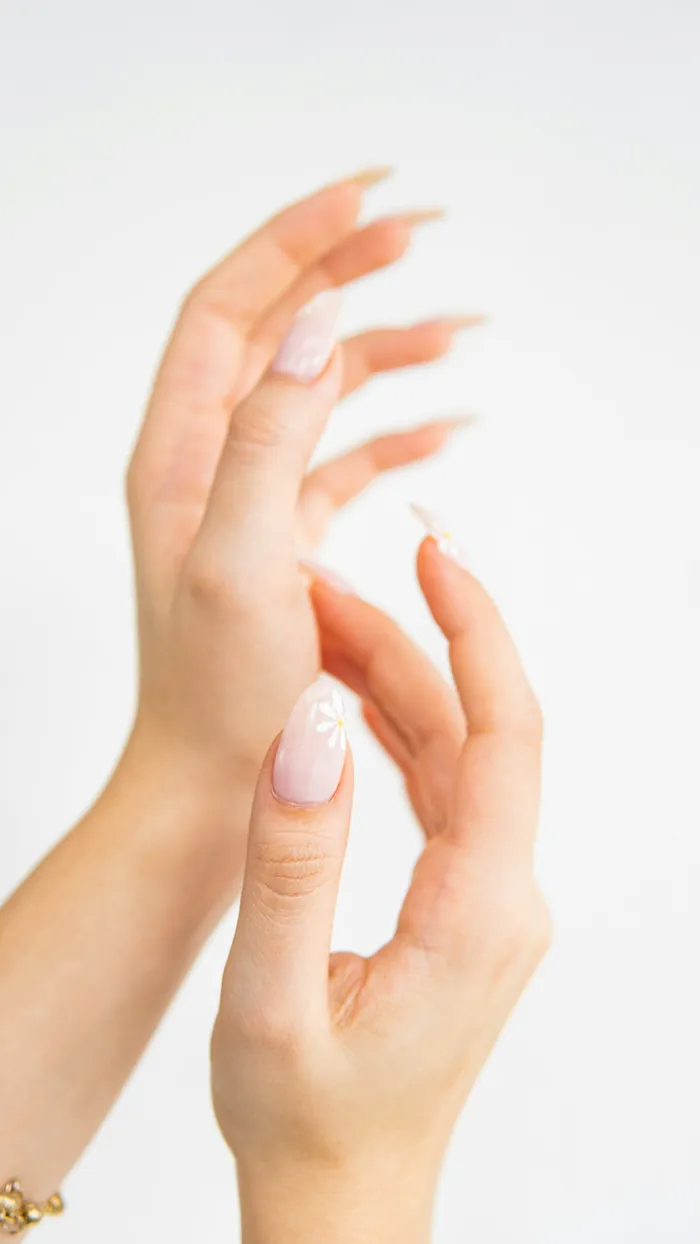 Mãos femininas com unhas claras e delicadas