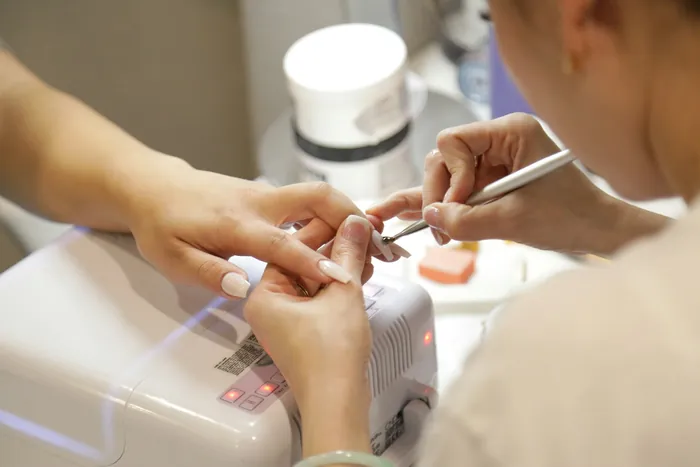 Procedimento de unhas em gel sendo realizado